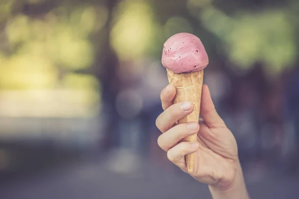 Woman is holding strawberry ice cream in her hand, beautiful sum — Stock Photo, Image