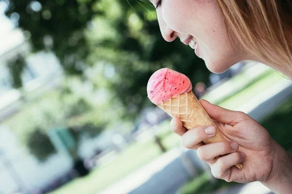 Smiling girl enjoys her strawberry ice cream during a summer day — Stock Photo, Image