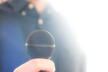 Gazeteci bir mikrofon bulanık bac ön planda tutuyor
