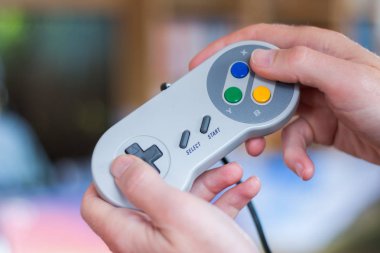 Eller bir retro video oyun denetleyicisi tutarak ve oynamak, blu