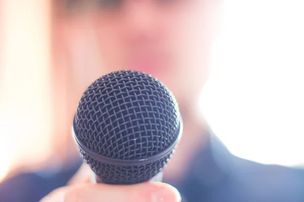 Press officer is speaking into a microphone and giving an interv — Stock Photo, Image