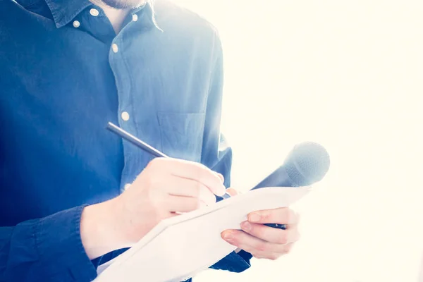 Manlig journalist på presskonferens, hålla mikrofonen och takin — Stockfoto