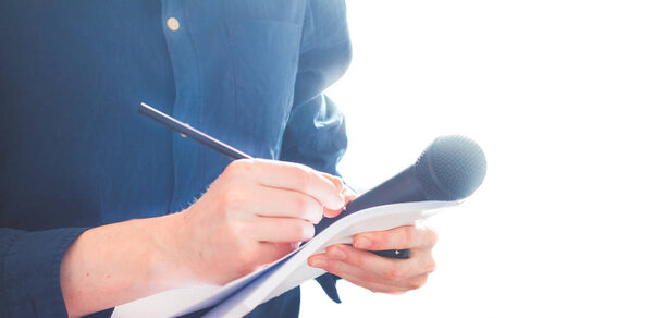 Мужчина журналист на пресс-конференции, держит микрофон и такин
