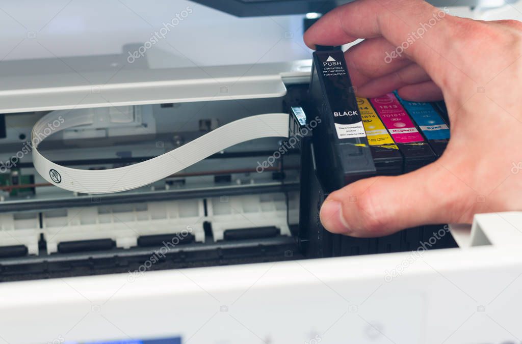 Putting new printer cartridge into the printer, inkjet.