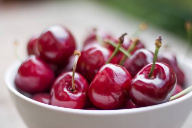 Açık havada bahçe bir masada bir kase taze kırmızı kiraz