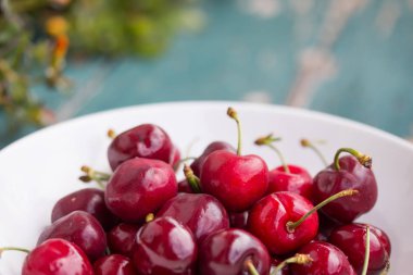 Açık havada bahçe bir masada bir kase taze kırmızı kiraz