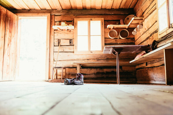 Alpine boots on rustic wood floor in an abandoned mountain chale