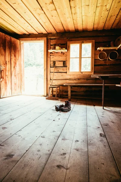 Bottes alpines sur sol bois rustique dans un chale de montagne abandonné — Photo