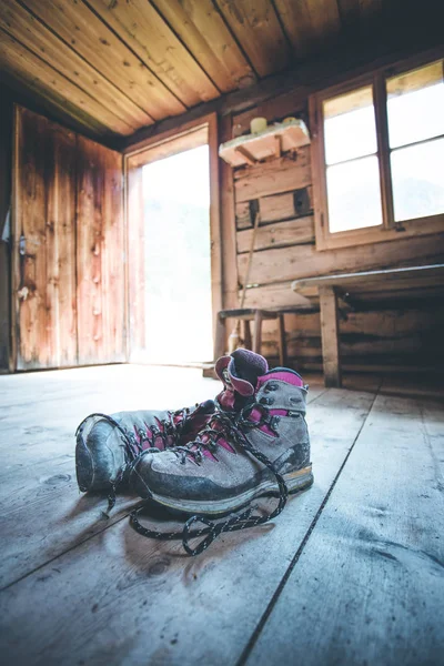 Botas alpinas sobre suelo rústico de madera en una col rizada abandonada —  Fotos de Stock