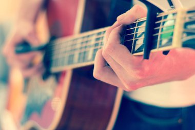 Genç bir adam bir sunburst Batı gitar çalmak boşaltma