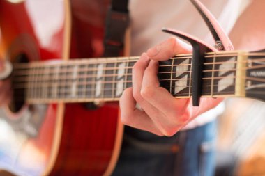 Genç bir adam bir sunburst Batı gitar çalmak boşaltma