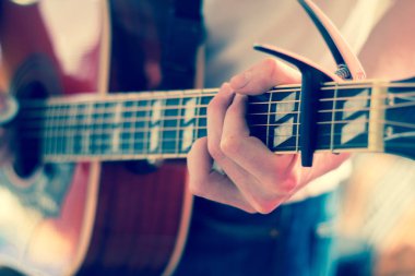 Genç bir adam bir sunburst Batı gitar çalmak boşaltma