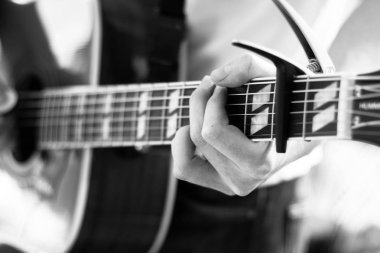 Genç bir adam bir sunburst Batı gitar çalmak boşaltma