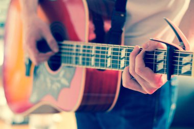 Genç bir adam bir sunburst Batı gitar çalmak boşaltma