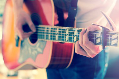 Genç bir adam bir sunburst Batı gitar çalmak boşaltma