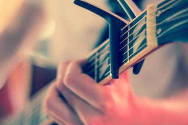 Genç bir adam bir sunburst Batı gitar çalmak boşaltma