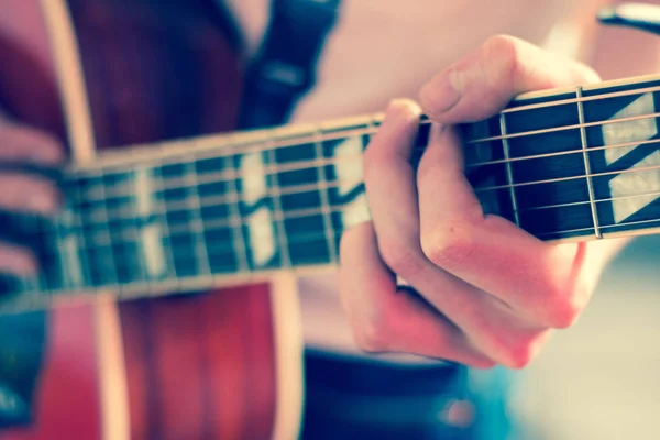 Corte de um jovem tocando uma guitarra ocidental sunburst — Fotografia de Stock