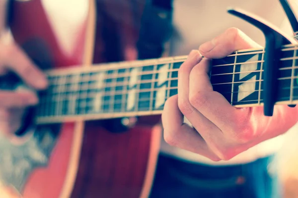 Corte de um jovem tocando uma guitarra ocidental sunburst — Fotografia de Stock