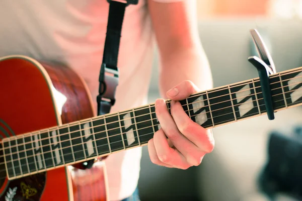 Вирізання молодого чоловіка, який грає на засніженій західній гітарі — стокове фото