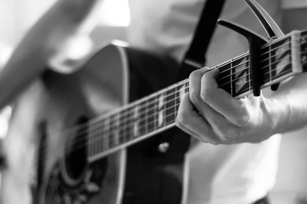 Recorte de un joven tocando una guitarra occidental sunburst — Foto de Stock