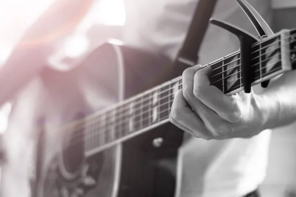 Recorte de un joven tocando una guitarra occidental sunburst — Foto de Stock