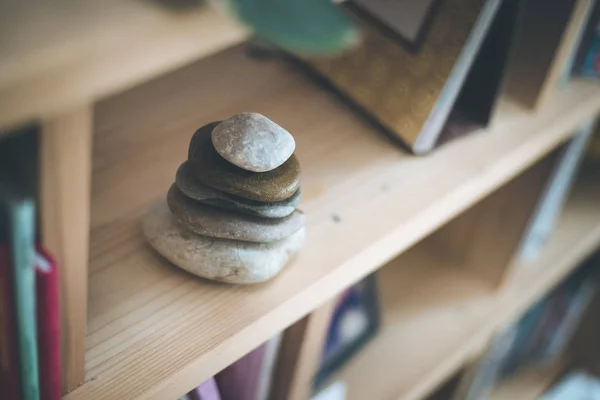 Feng Shui: cairn de piedra en un estante de libros en la sala de estar, balan —  Fotos de Stock