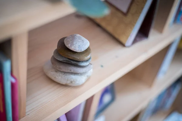 Feng Shui: cairn de piedra en un estante de libros en la sala de estar, balan —  Fotos de Stock