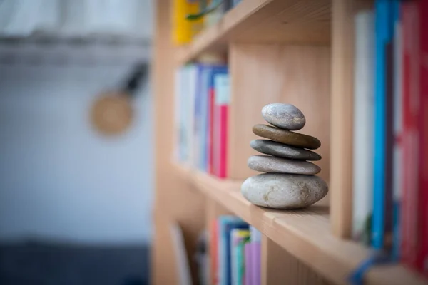 Feng Shui: cairn de piedra en un estante de libros en la sala de estar, balan —  Fotos de Stock