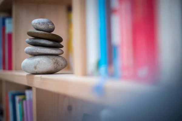 Feng Shui: Stone cairn w półkę na książki w salonie, balan — Zdjęcie stockowe