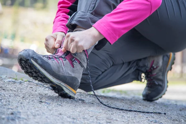 Vrouw is koppelverkoop haar wandelen laarzen, voorbereidingen voor een reis — Stockfoto