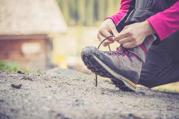 Vrouw is koppelverkoop haar wandelen laarzen, voorbereidingen voor een reis — Stockfoto