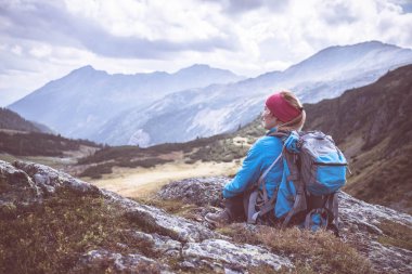 Dağcı sırt çantası ile taşlı yerde oturan bir
