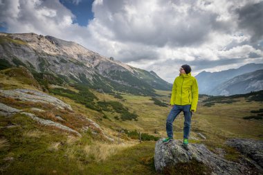 Erkek spor giyim ve sırt çantası ile belgili tanımlık dağ görünümünde sahiptir