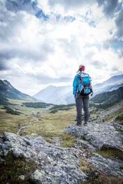 Kadın sarışın dağcı sırt çantası ile vie keyif alıyor