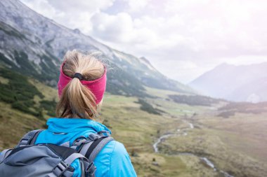 Kadın sarışın dağcı sırt çantası ile vie keyif alıyor
