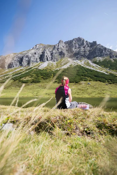 Bergbeklimmer is zittend op de grond en doet een pauze-duri — Stockfoto