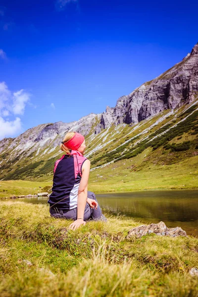 Montañista está sentado en el suelo y haciendo un descanso duri — Foto de Stock