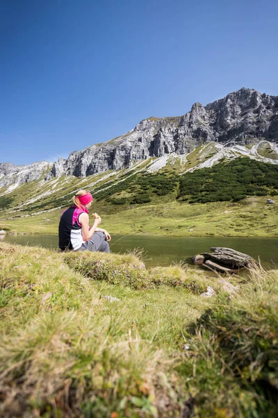 Bergbeklimmer is zittend op de grond en doet een pauze-duri — Stockfoto