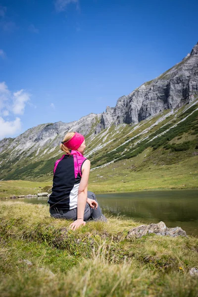 Montañista está sentado en el suelo y haciendo un descanso duri — Foto de Stock