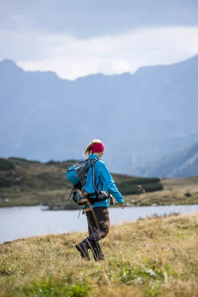 Wandelaar in laarzen en met rugzak loopt VN het upland, Austr — Stockfoto