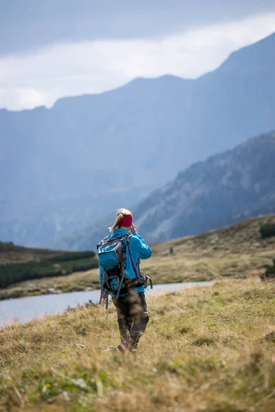 Wandelaar in laarzen en met rugzak loopt VN het upland, Austr — Stockfoto