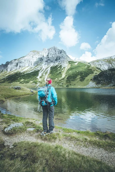 Vrouw in sportkleding en met rugzak geniet van het uitzicht in het mou — Stockfoto