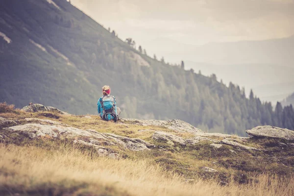 Bergbeklimmer met rugzak zit op de stenige grond een — Stockfoto