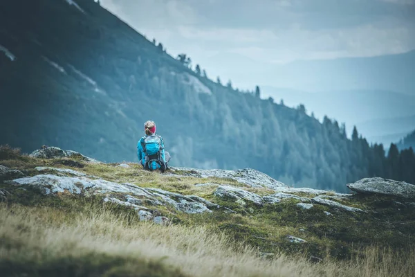 Alpinista de montanha com mochila está sentado no chão pedregoso e — Fotografia de Stock