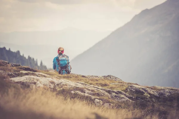 Bergbeklimmer met rugzak zit op de stenige grond een — Stockfoto