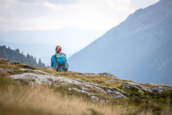 Montañista con mochila está sentado en el suelo pedregoso un — Foto de Stock