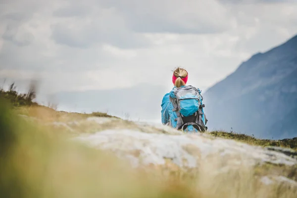 Гірський альпініст з рюкзаком сидить на кам'янистій землі — стокове фото