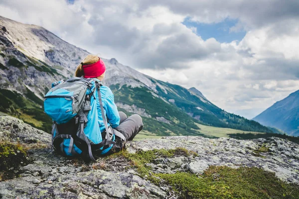 Montañista con mochila está sentado en el suelo pedregoso un — Foto de Stock