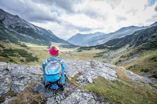 Bergbeklimmer met rugzak zit op de stenige grond een — Stockfoto