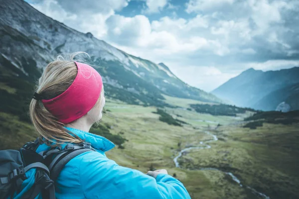 Female blonde mountain climber with backpack is enjoying the vie — Stock Photo, Image